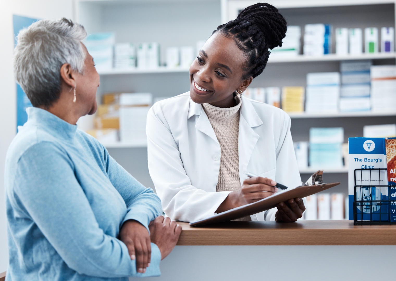 A pharmacist talks to a customer over a chart.